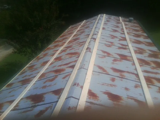 Rusted metal roof panels with new wood purlins before replacement — Storm Damage Roof Repair in Calhoun by Roofing Brothers